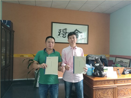 油漆涂料經銷商何總（左）與數碼彩漆銷售總監蔣方海合影